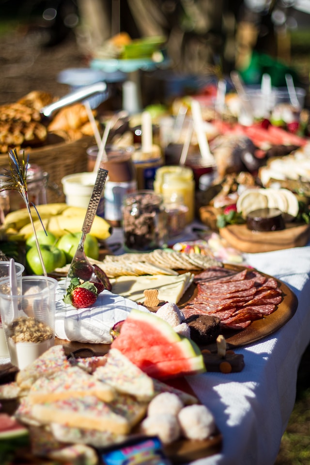 An image of a buffet of food, including cold meat, cheese, fruit and crackers